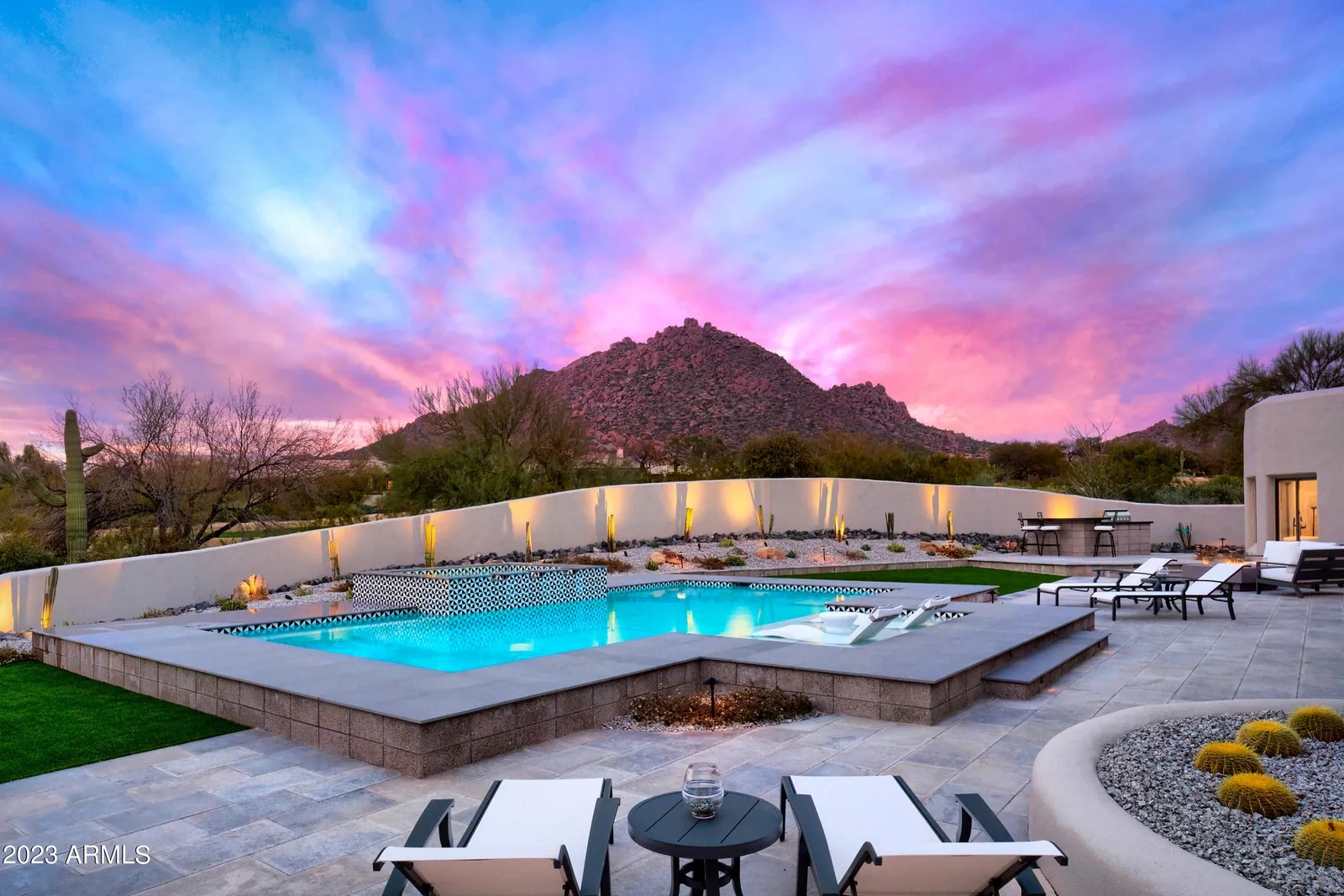 Backyard pool beneath a desert mountain at sunset