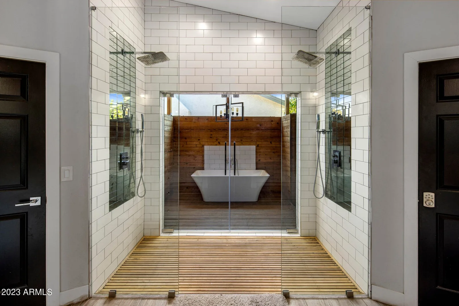 Walk-through shower and soaking tub with tile, wood accents, and glass enclosure