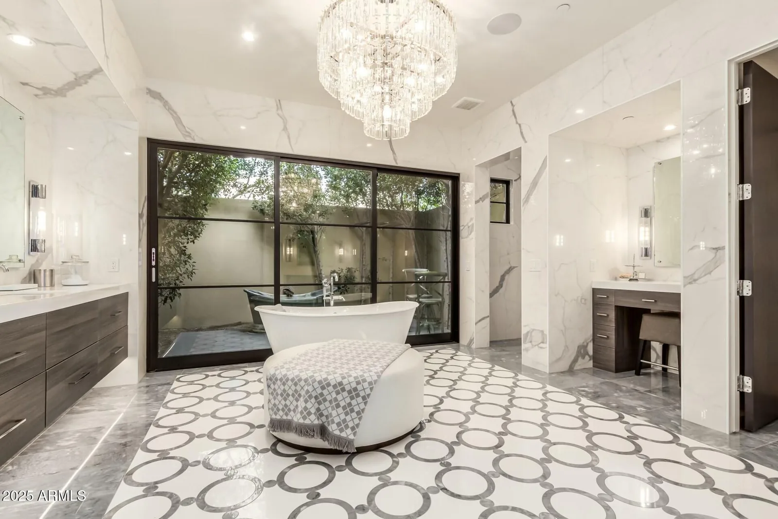 Marble bathroom with a freestanding tub, double vanities, and garden-facing windows