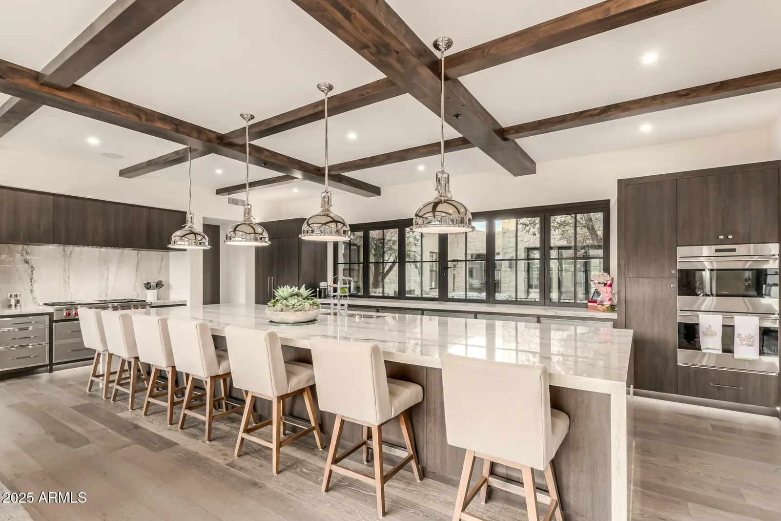 Kitchen with a stone island, dark wood cabinetry, and exposed beams