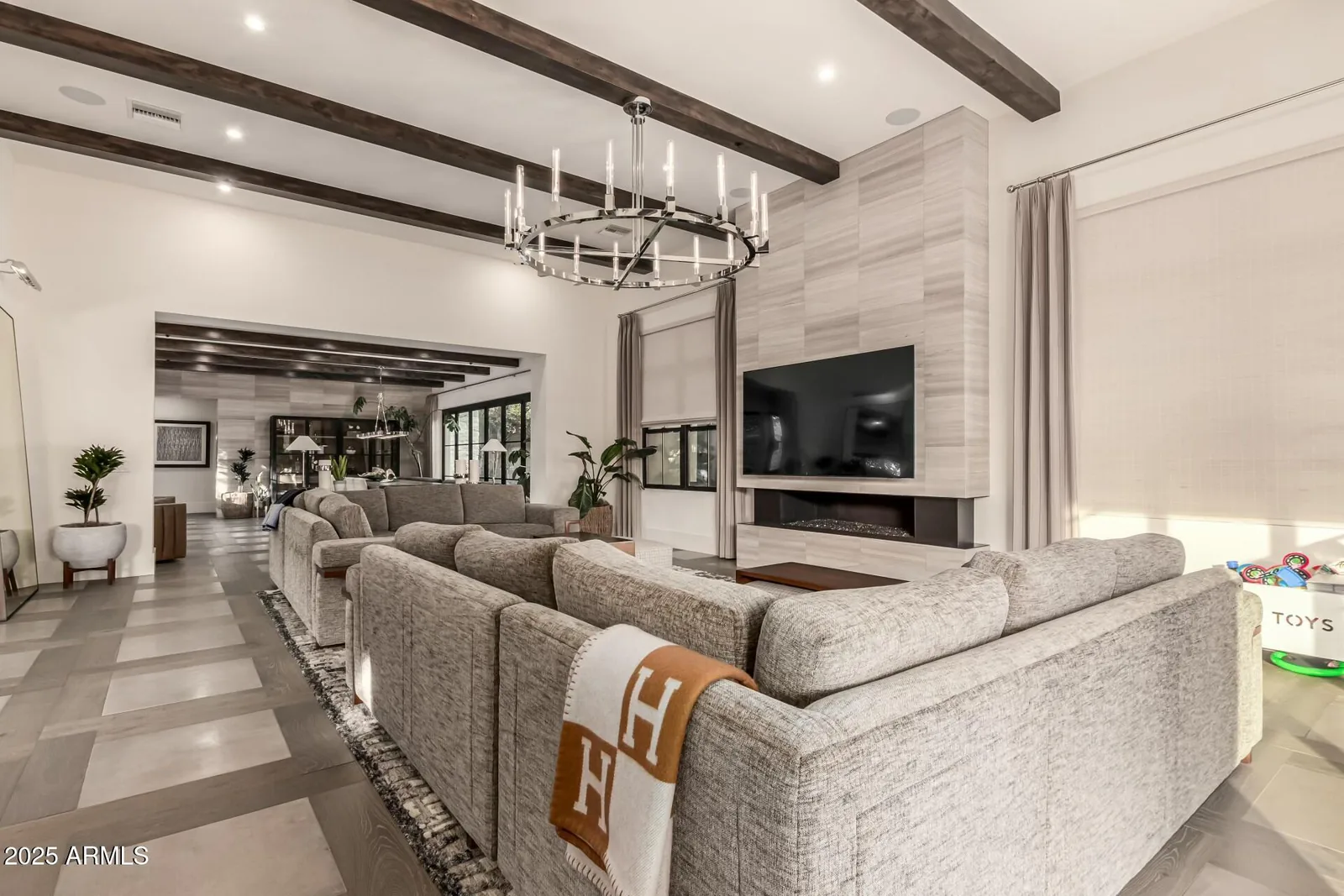 Living room with exposed wood beams, a fireplace, and contemporary seating