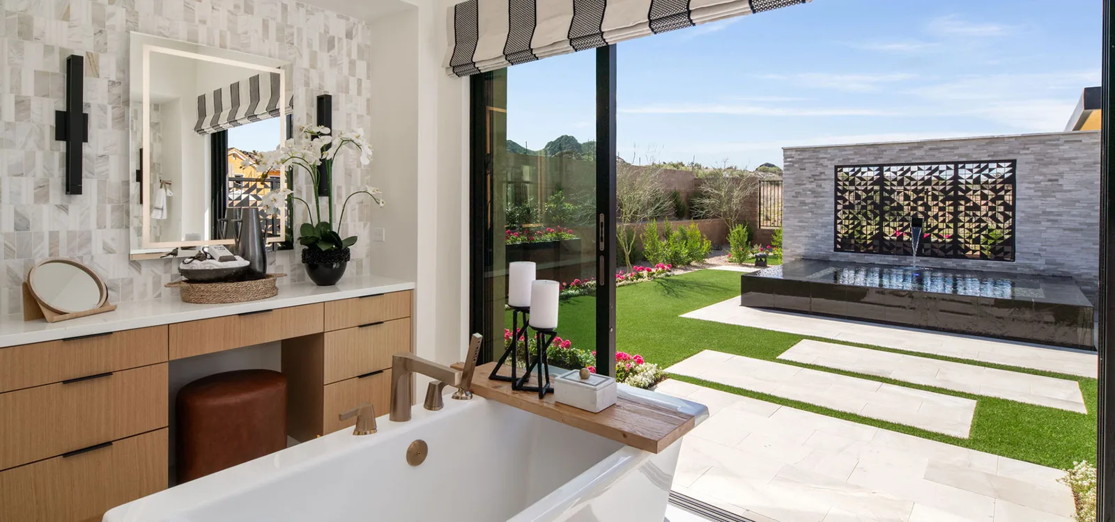 Bathroom vanity beside a large window looking onto a landscaped courtyard