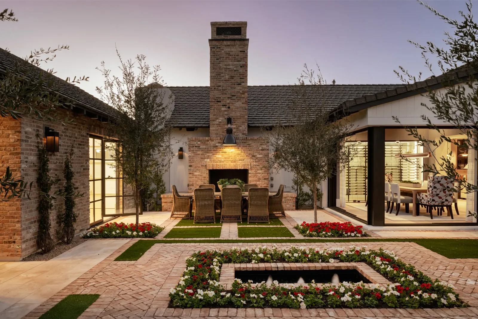 Stone courtyard with an outdoor dining area, garden beds, and a reflecting pool